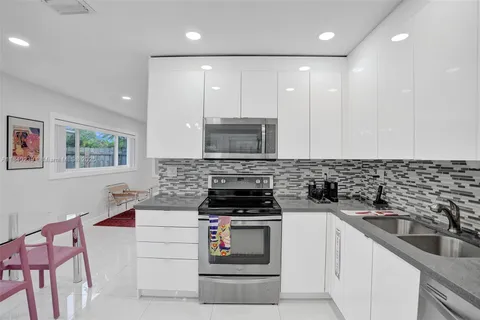 a kitchen with a sink stove top oven and cabinets
