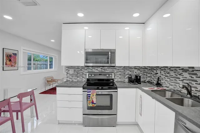 a kitchen with a sink stove top oven and cabinets