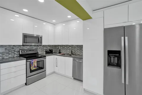 a kitchen with stainless steel appliances granite countertop a refrigerator and a stove top oven