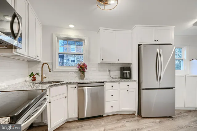 a kitchen with appliances a sink and lots of cabinets