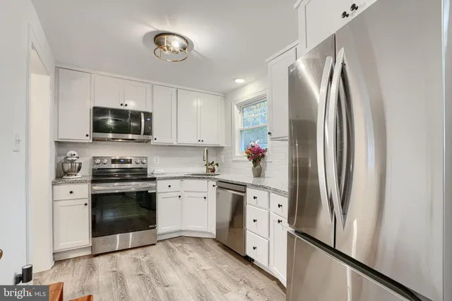 a kitchen with stainless steel appliances a refrigerator sink and microwave
