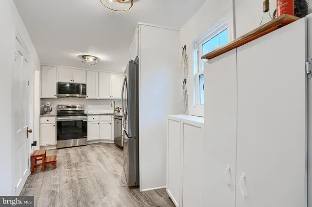 a kitchen with stainless steel appliances a refrigerator and a stove top oven