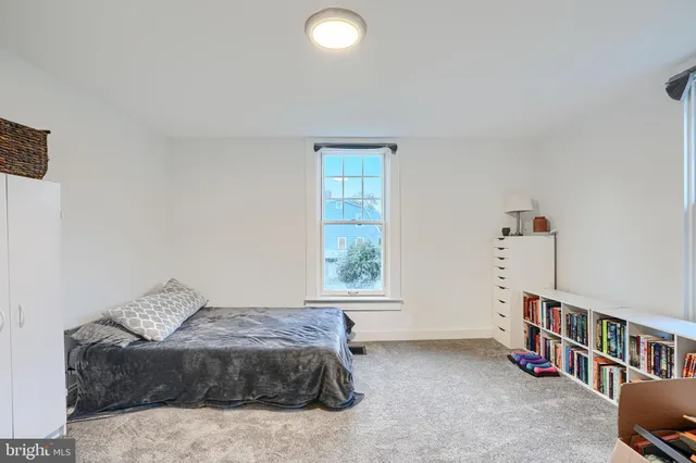 a bedroom with a bed and a book shelf