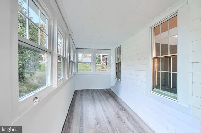a view of hallway with a large window and wooden floor