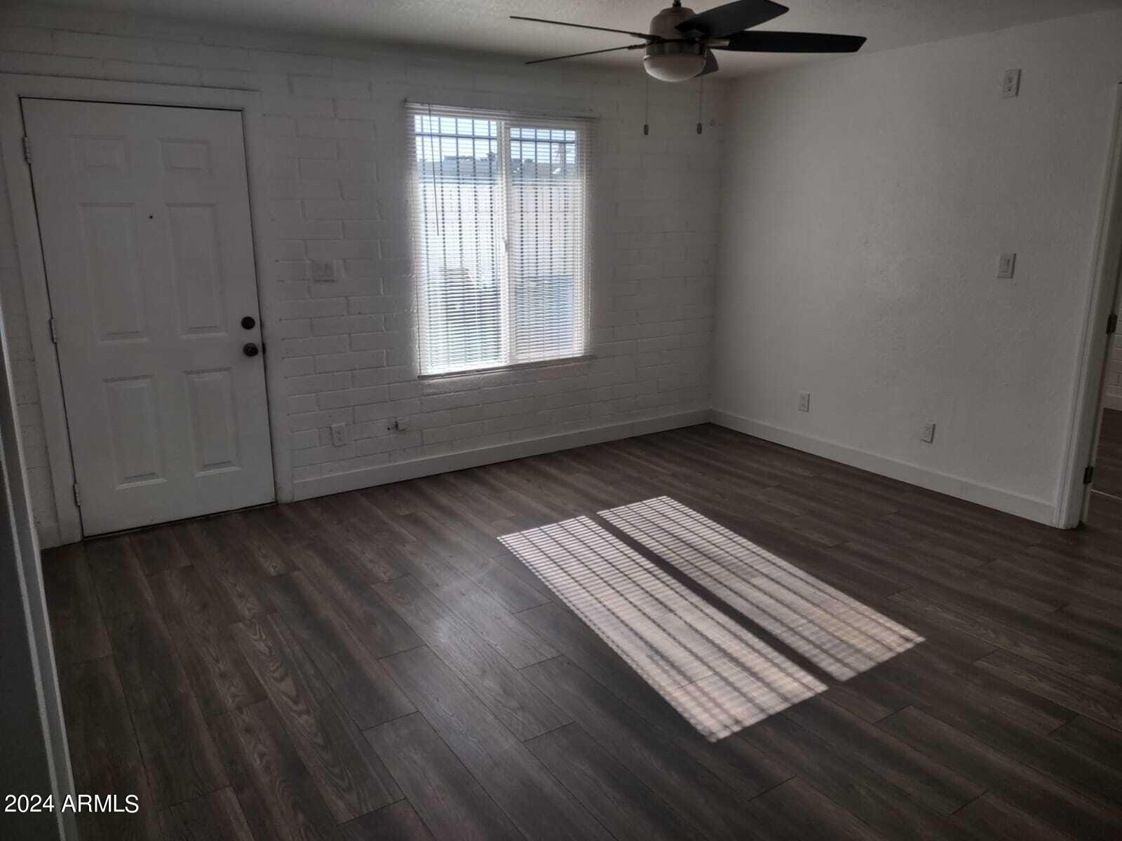 3224 West Jackson Street, Unit 3 Phoenix, AZ 85009 - Photo 4 of 8 an empty room with wooden floor cabinet and windows