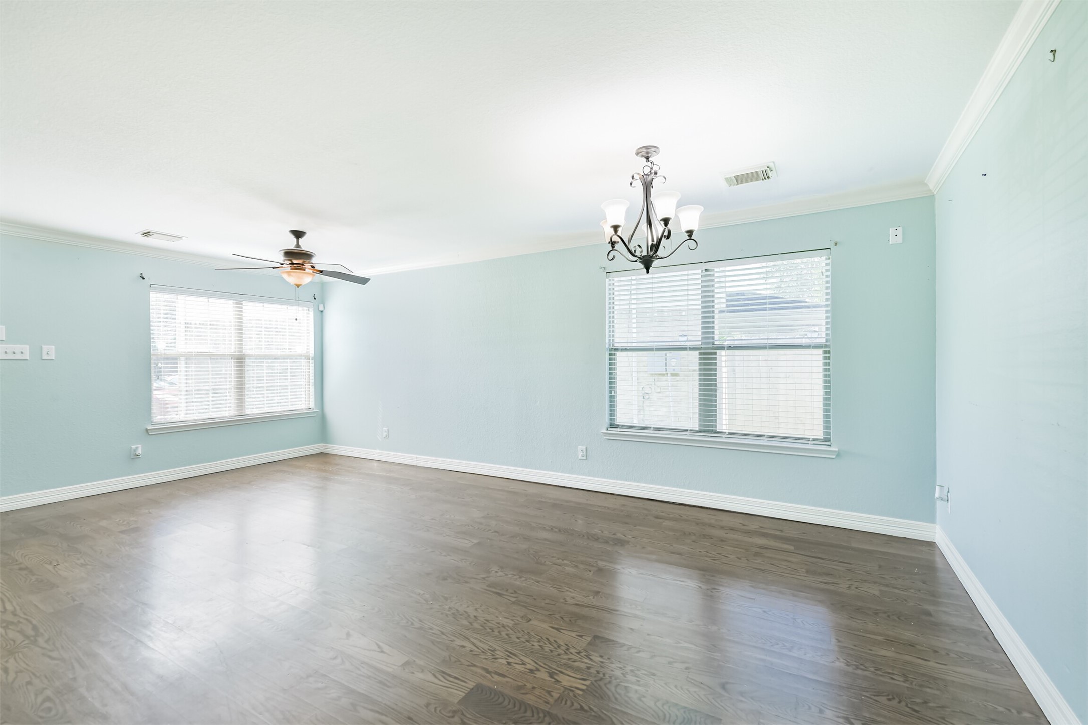 9207 Cribbage Court Houston, TX 77083 - Photo 12 of 47 an empty room with wooden floor chandelier and windows