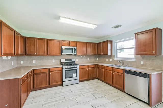 a view of a kitchen with a sink and dishwasher cabinet a fireplace