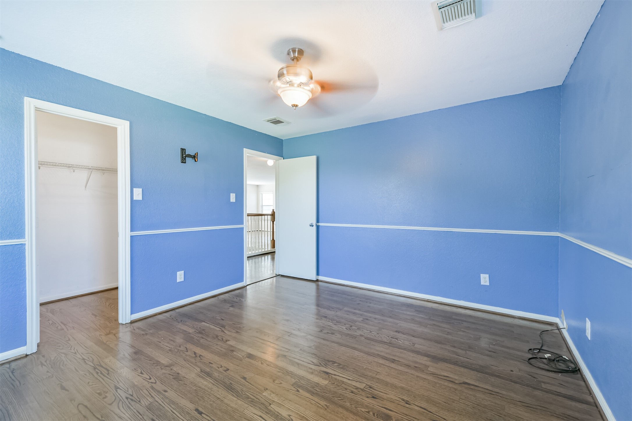 9207 Cribbage Court Houston, TX 77083 - Photo 32 of 47 an empty room with wooden floor and chandelier fan