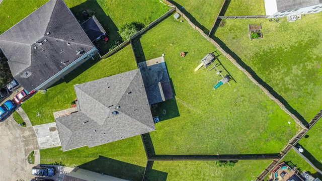 an empty room with wooden floor cabinet and windows