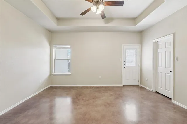 an empty room with closet and a ceiling fan