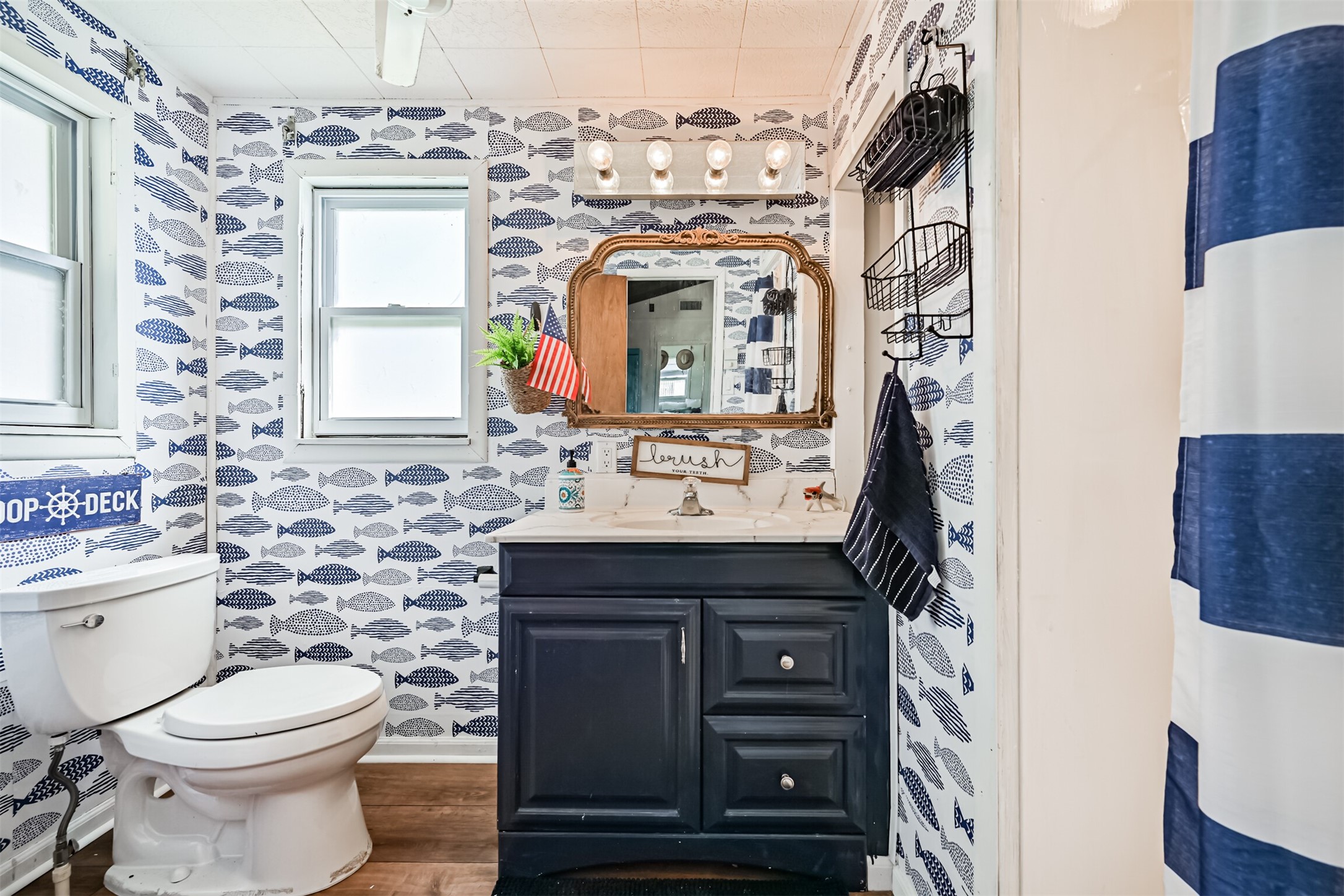 16519 Captain Kidd Road Jamaica Beach, TX 77554 - Photo 16 of 32 a bathroom with a sink a toilet and a mirror