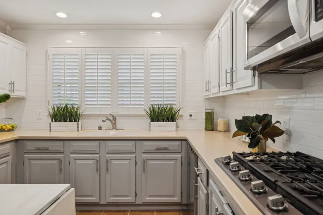 a kitchen with white cabinets and white appliances