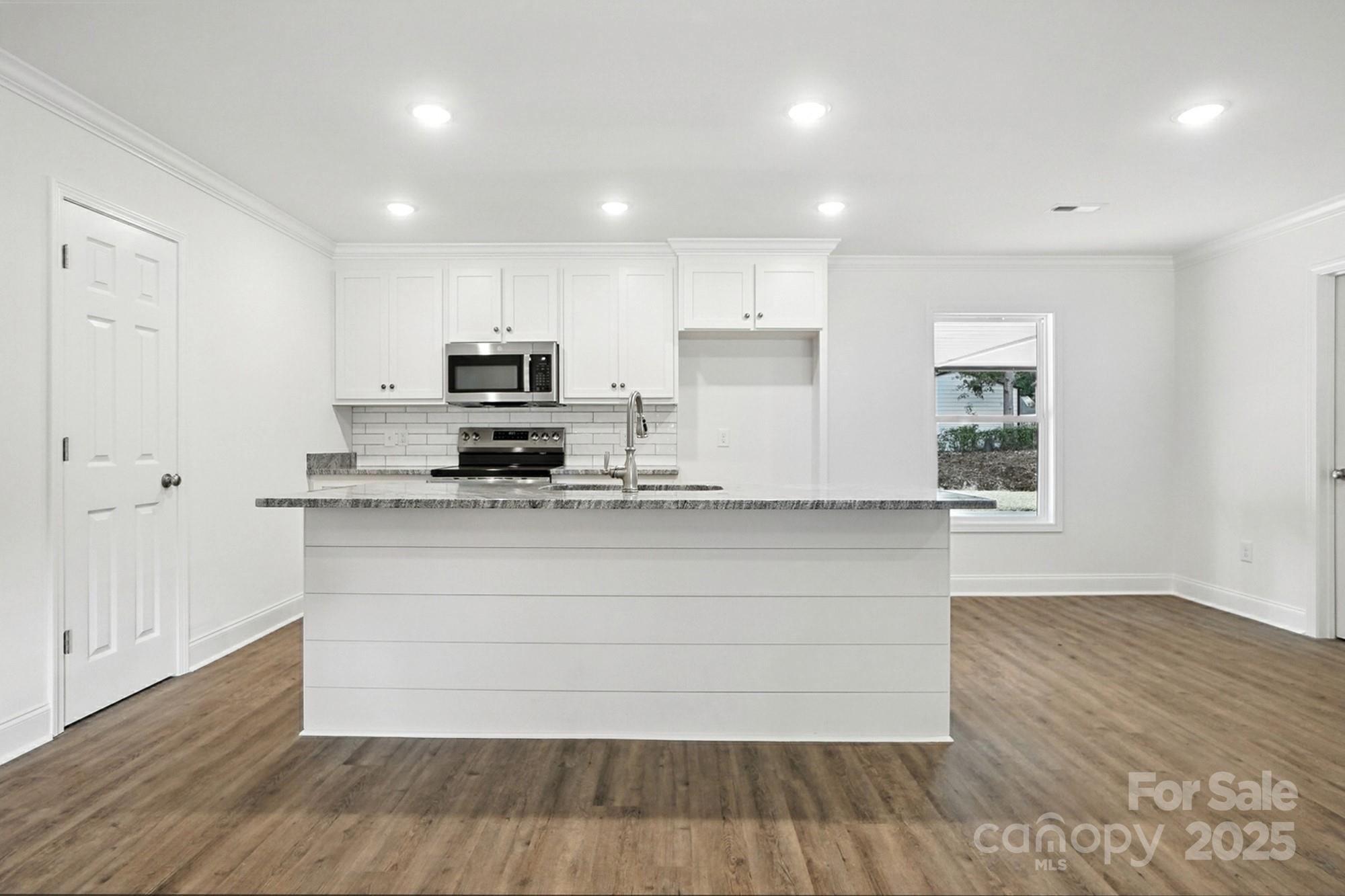 251 Lincoln Road York, SC 29745 - Photo 8 of 30 a kitchen with granite countertop white cabinets and a wooden floor