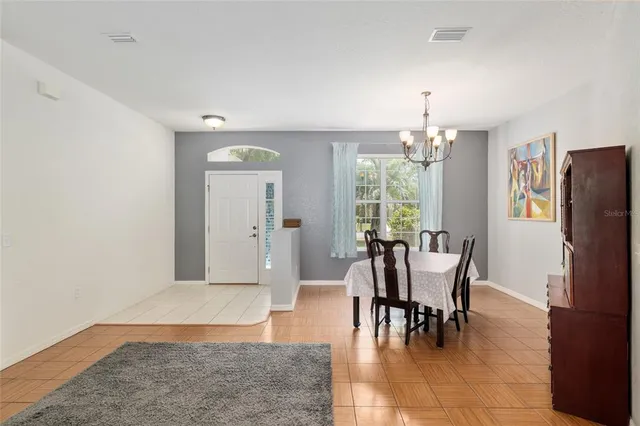 a view of a dining room with furniture a chandelier and wooden floor