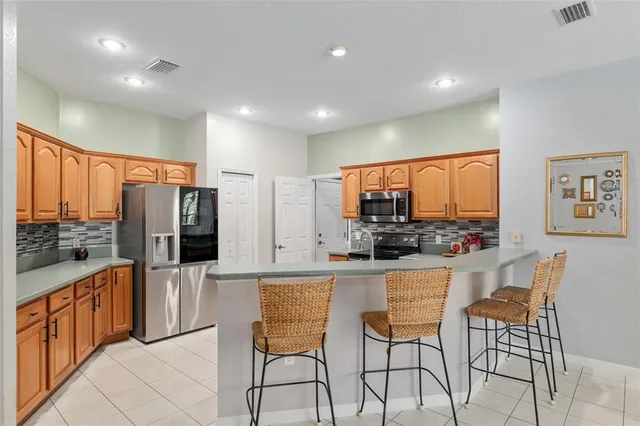 a kitchen with stainless steel appliances granite countertop a stove a sink and a refrigerator