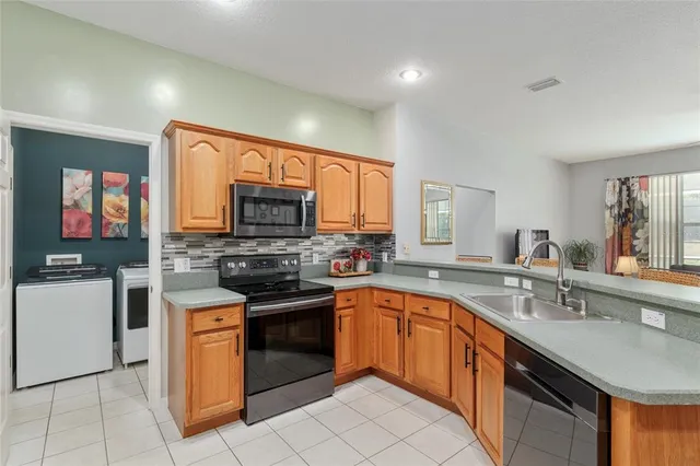 a kitchen with stainless steel appliances granite countertop a sink and a wooden cabinets