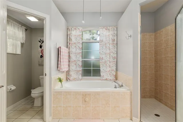 a bedroom with furniture and a chandelier fan