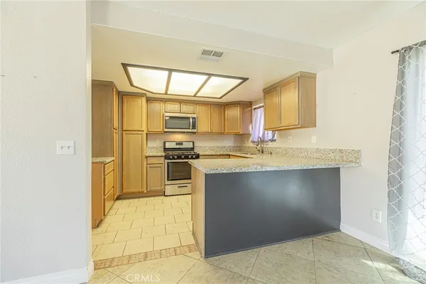 a kitchen with stainless steel appliances a stove a sink and a microwave