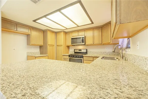 a kitchen with stainless steel appliances a stove a sink and a refrigerator