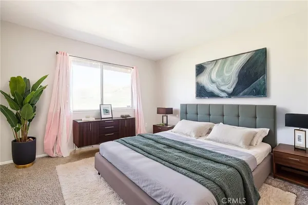 a bedroom with a large bed and a potted plant