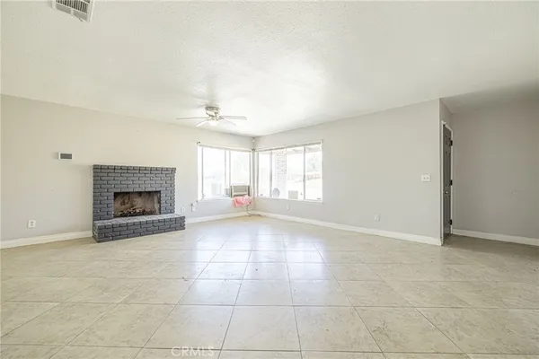 a view of an empty room with a fireplace and a window