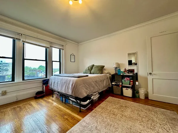 a bed sitting in a spacious bedroom next to a window