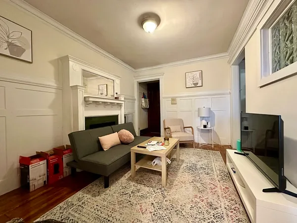 a living room with furniture a rug and a flat screen tv