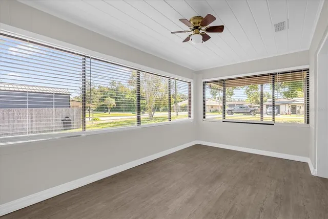 a view of an empty room with a window and a ceiling fan