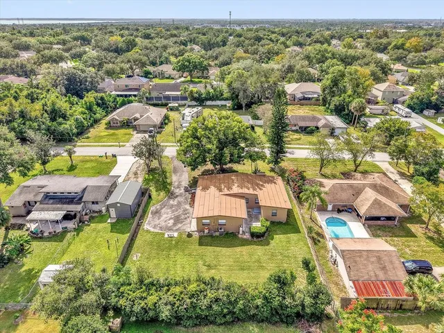 an aerial view of residential houses with outdoor space and parking