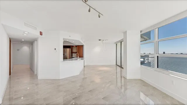 a kitchen with stainless steel appliances a stove a sink a oven and white cabinets with wooden floor