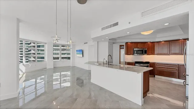 a kitchen with stainless steel appliances kitchen island granite countertop a stove a sink and a microwave