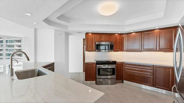 a kitchen with stainless steel appliances granite countertop a refrigerator and a sink