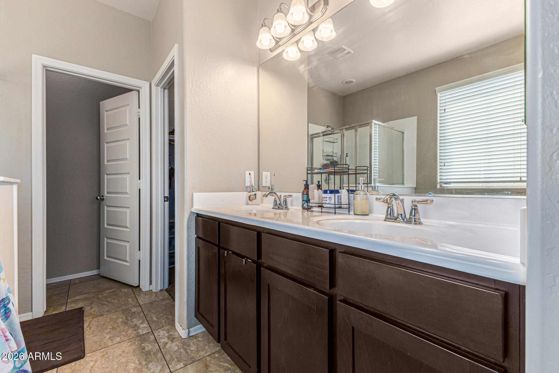 12214 West Del Rio Lane Avondale, AZ 85323 - Photo 16 of 32 a bathroom with a sink a large mirror and a light fixture