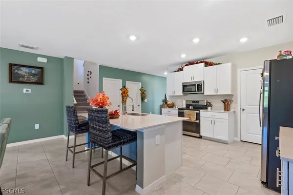 a kitchen with white cabinets and appliances