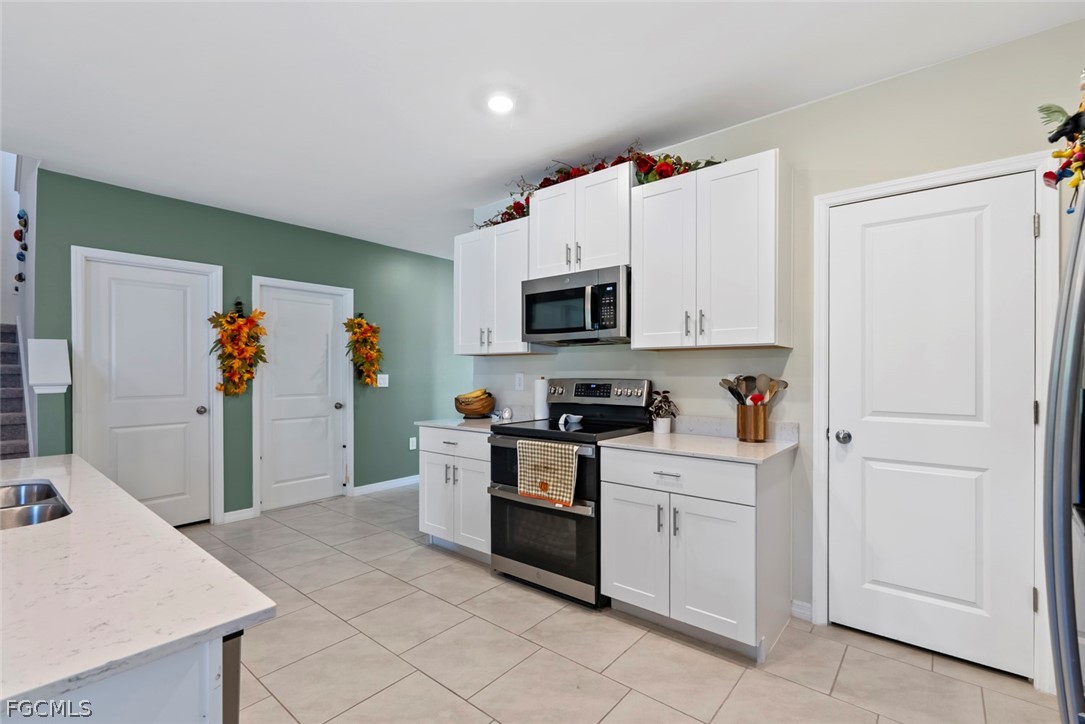 19972 Green Pasture Road Lehigh Acres, FL 33974 - Photo 12 of 48 a kitchen with white cabinets and appliances