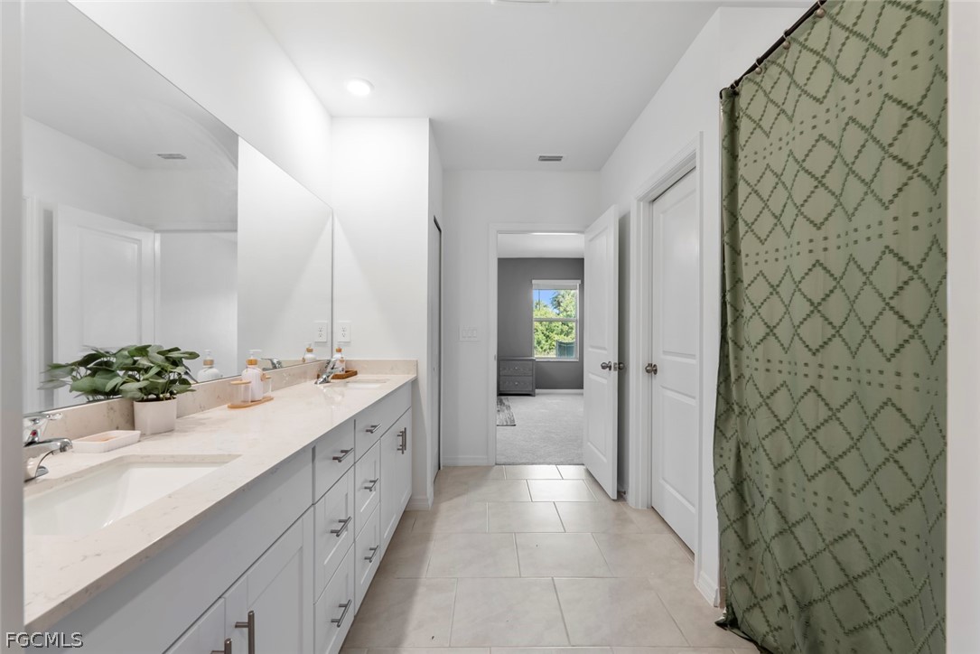 19972 Green Pasture Road Lehigh Acres, FL 33974 - Photo 19 of 48 a spacious bathroom with a double vanity sink mirror and shower