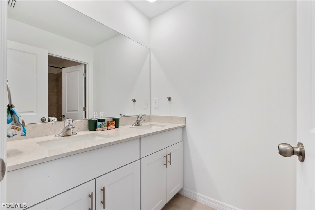 19972 Green Pasture Road Lehigh Acres, FL 33974 - Photo 24 of 48 a bathroom with a double vanity sink and mirror