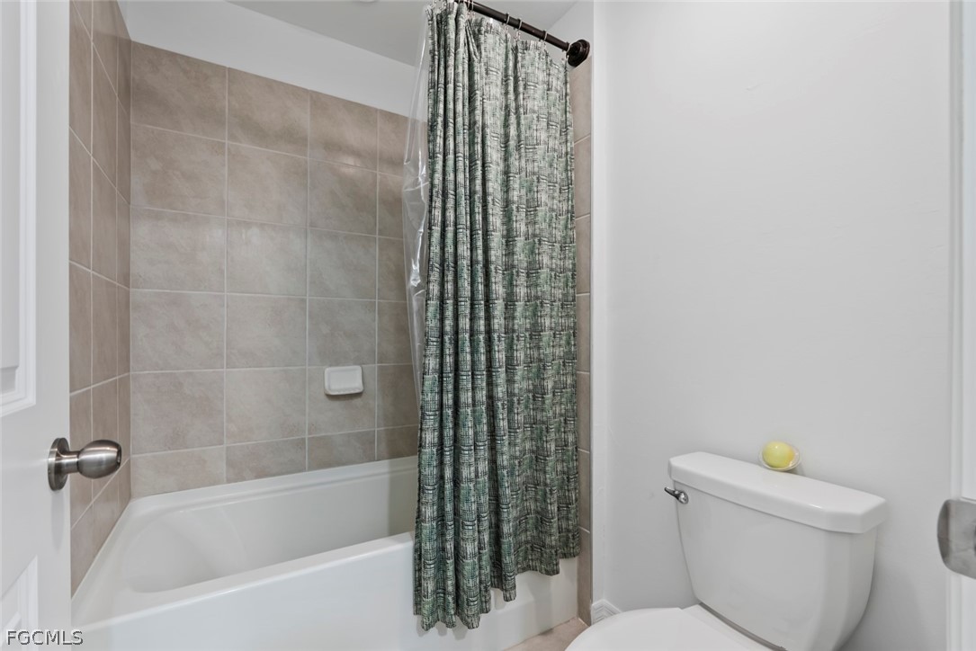 19972 Green Pasture Road Lehigh Acres, FL 33974 - Photo 25 of 48 a bathroom with a shower and a toilet