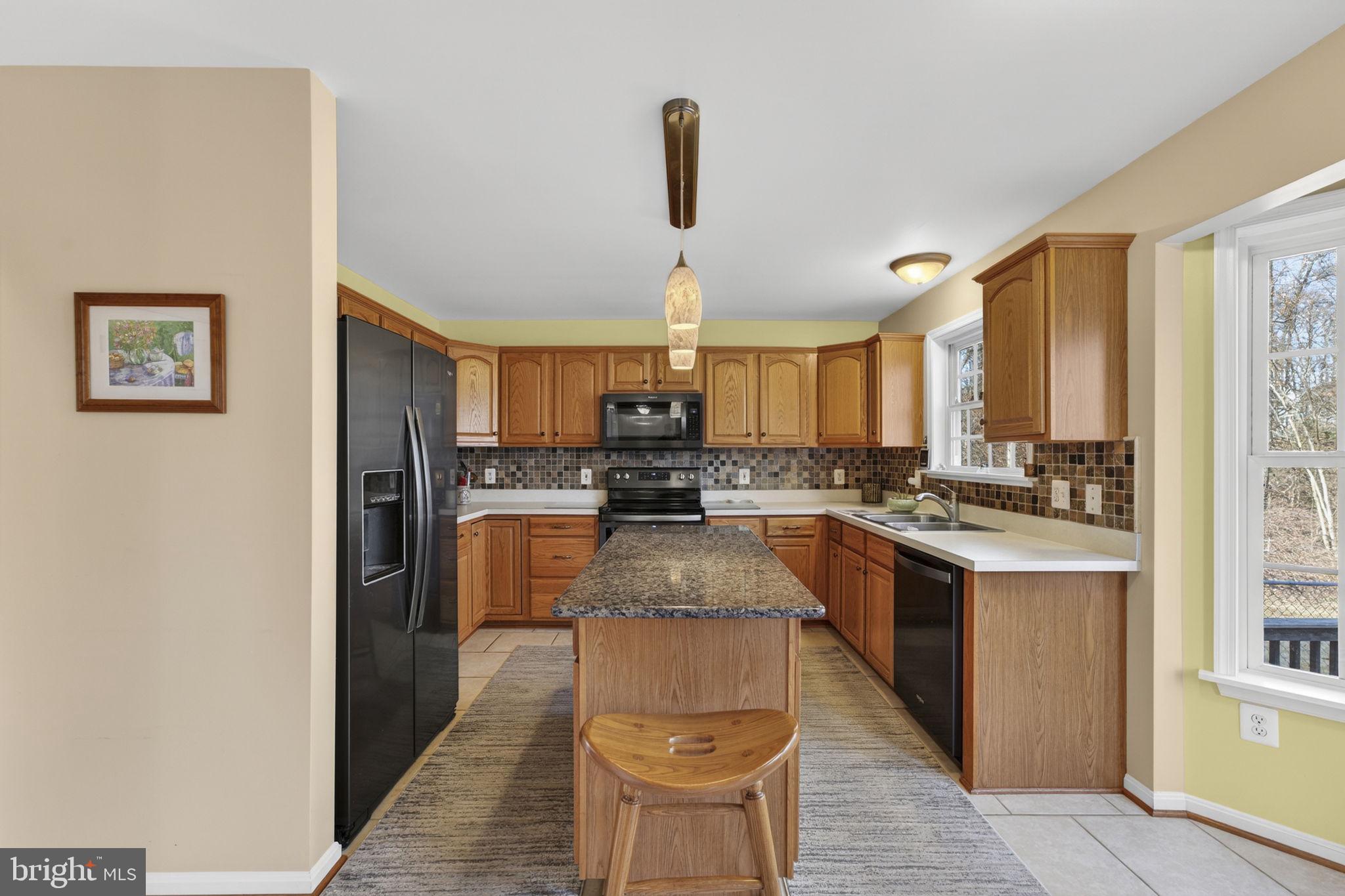 12376 Robin Road Culpeper, VA 22701 - Photo 33 of 70 a kitchen with stainless steel appliances granite countertop a stove top oven a sink dishwasher and a refrigerator with wooden floor