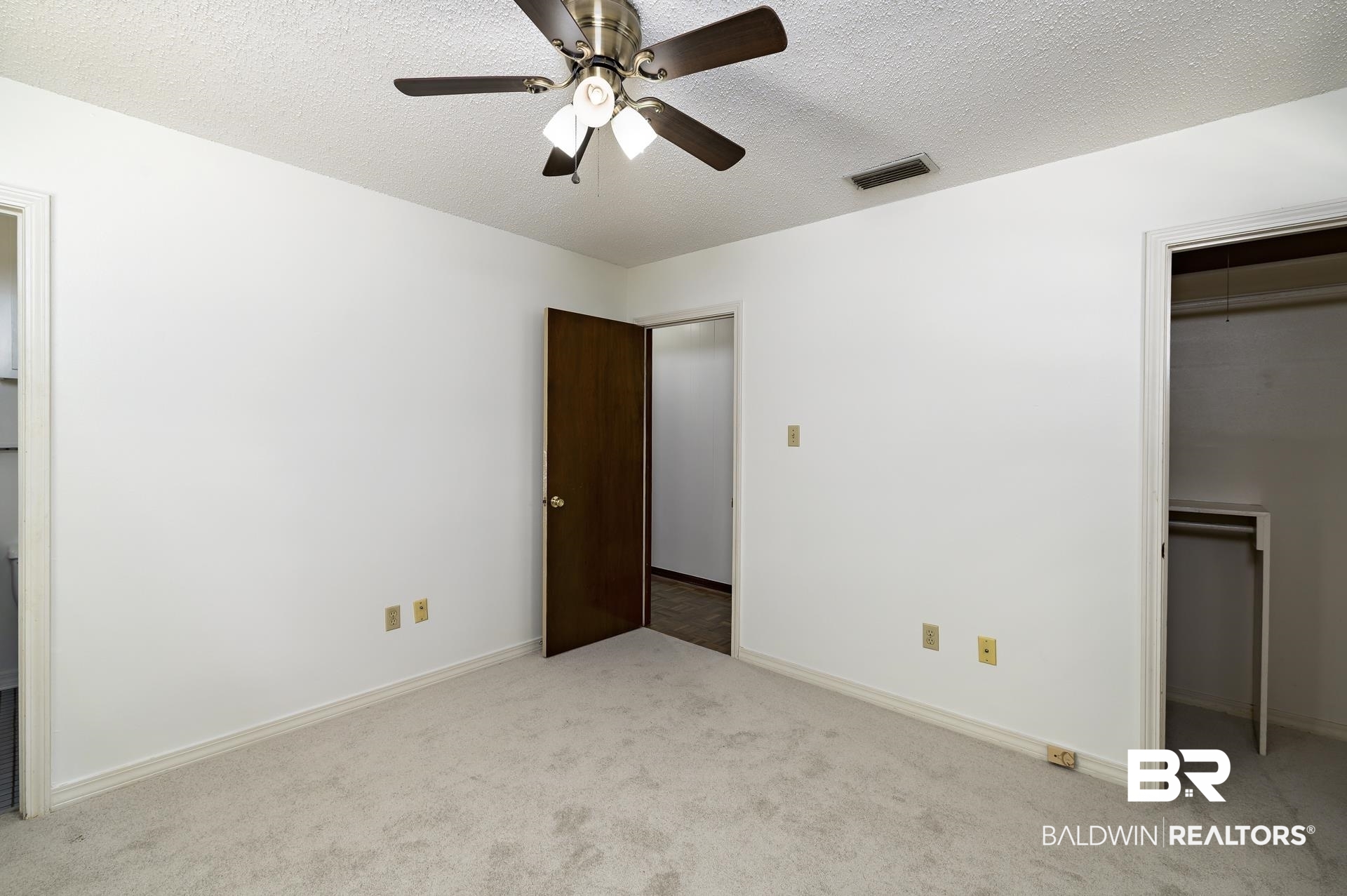707 Johnson Avenue Fairhope, AL 36532 - Photo 35 of 38 Unfurnished bedroom featuring visible vents, a spacious closet, carpet flooring, and attic access