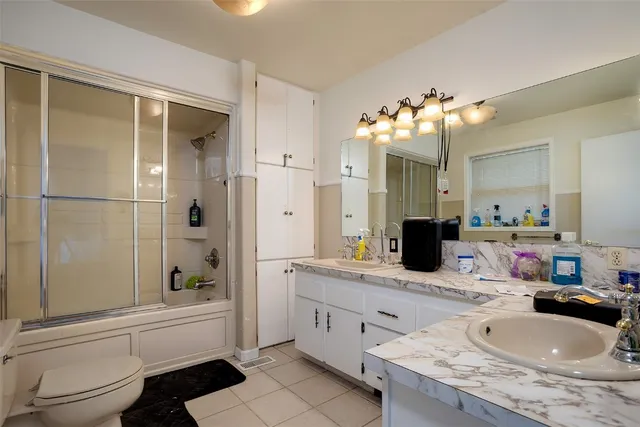 a bathroom with a granite countertop sink a toilet and shower