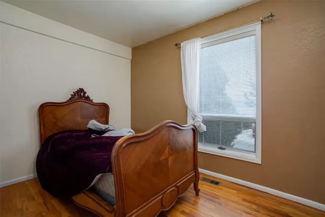 a bed sitting in a bedroom next to a window