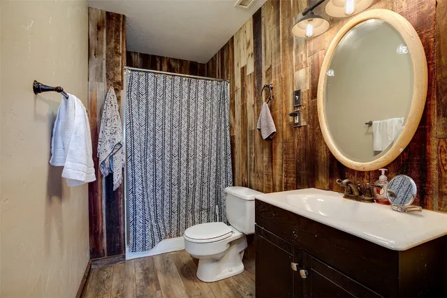 a bathroom with a sink vanity mirror and toilet
