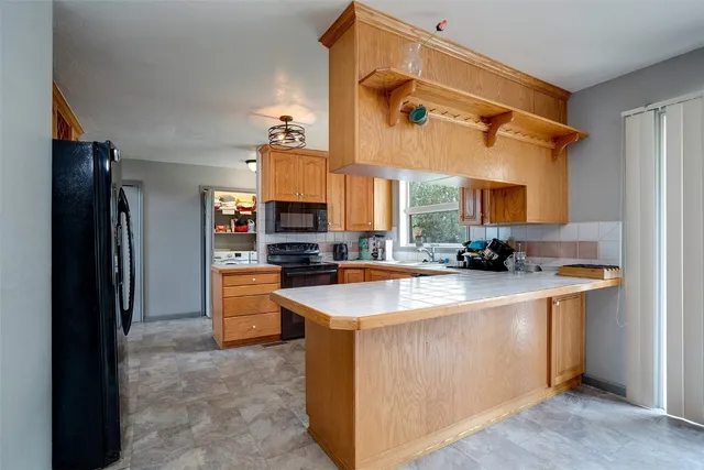 a kitchen with stainless steel appliances granite countertop a sink a stove and refrigerator