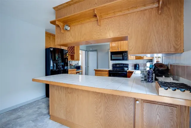 a kitchen with stainless steel appliances a stove a refrigerator a sink a counter top space and cabinets