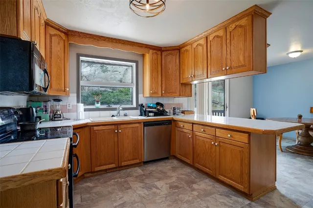 a kitchen with stainless steel appliances granite countertop wooden cabinets a sink and a stove