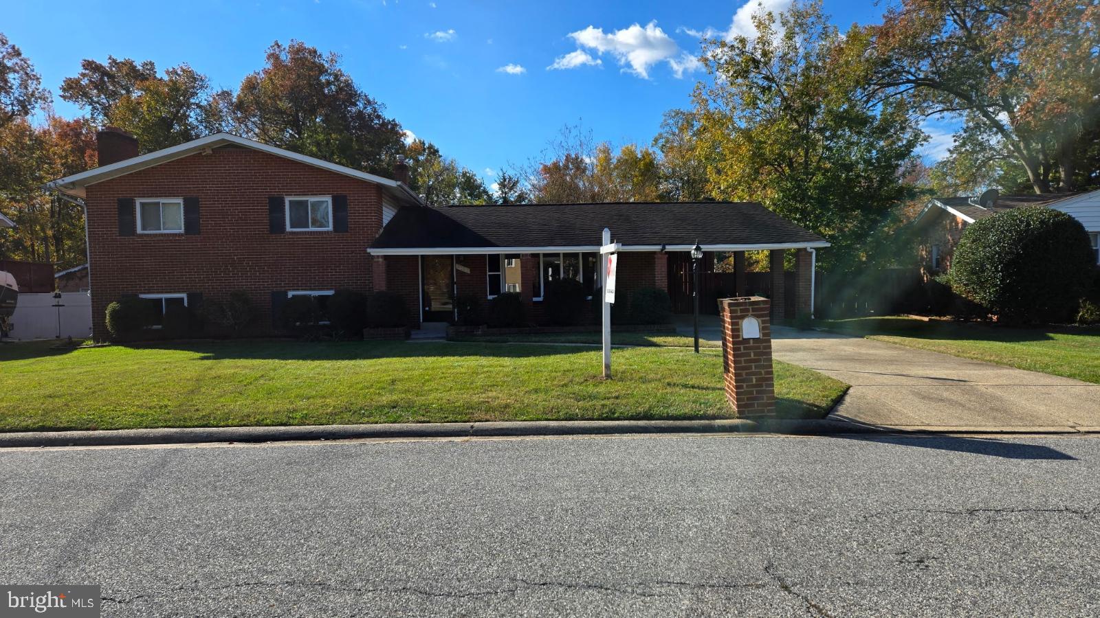 a view of a house with a yard and a large tree