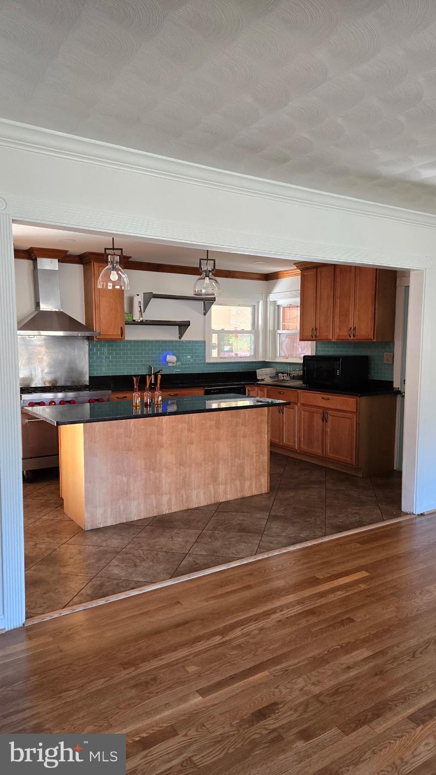 2105 Calhoun Street Fort Washington, MD 20744 - Photo 6 of 13 a kitchen with kitchen island granite countertop a stove and a wooden floor