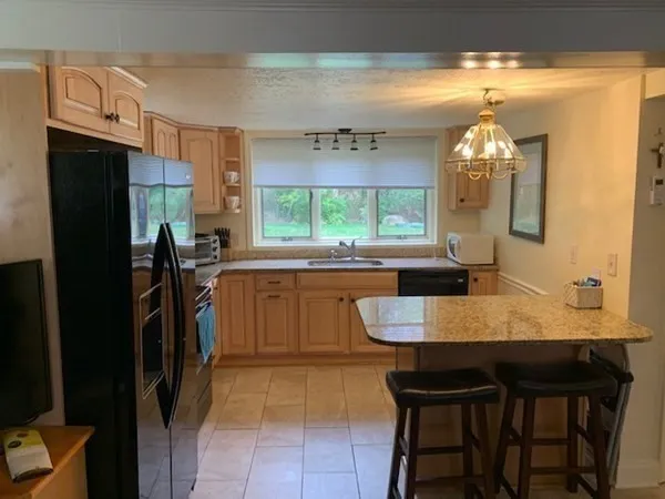 a kitchen with a sink refrigerator and window