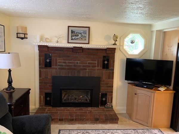 90 Lookout Point Road Plymouth, MA 02360 - Photo 5 of 10 a living room with furniture a fireplace and a flat screen tv